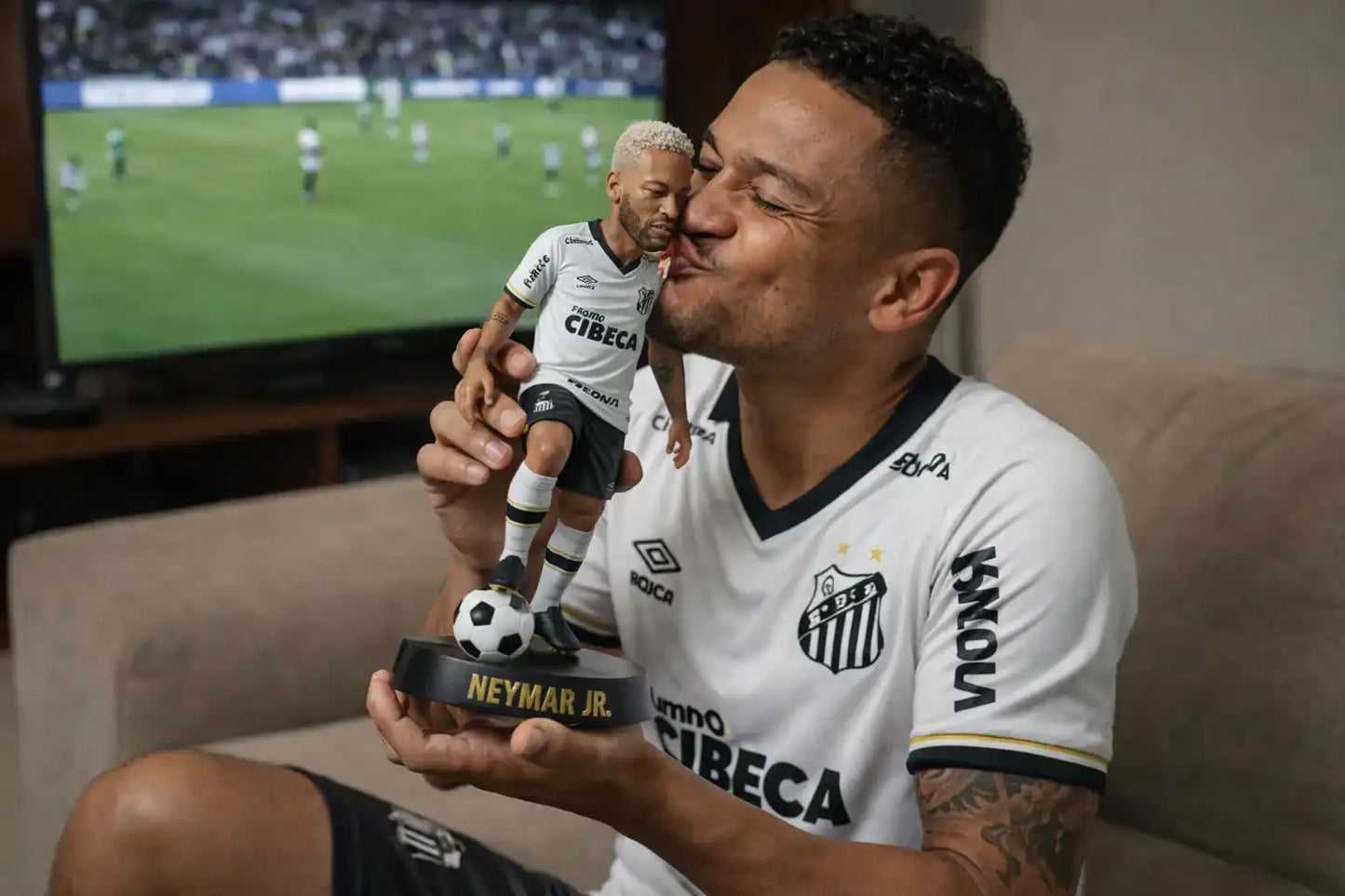 Homem segurando estatueta personalizada 3D de jogador de futebol com uniforme branco